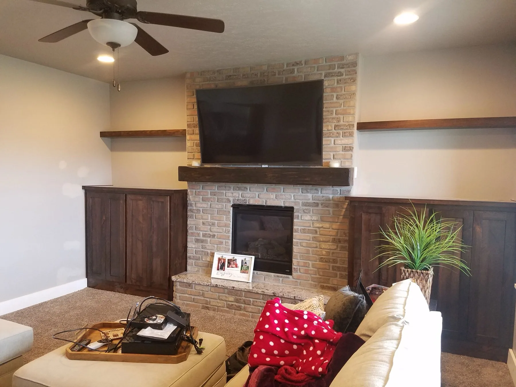 Stained entertainment built-ins with beam mantel and floating shelves