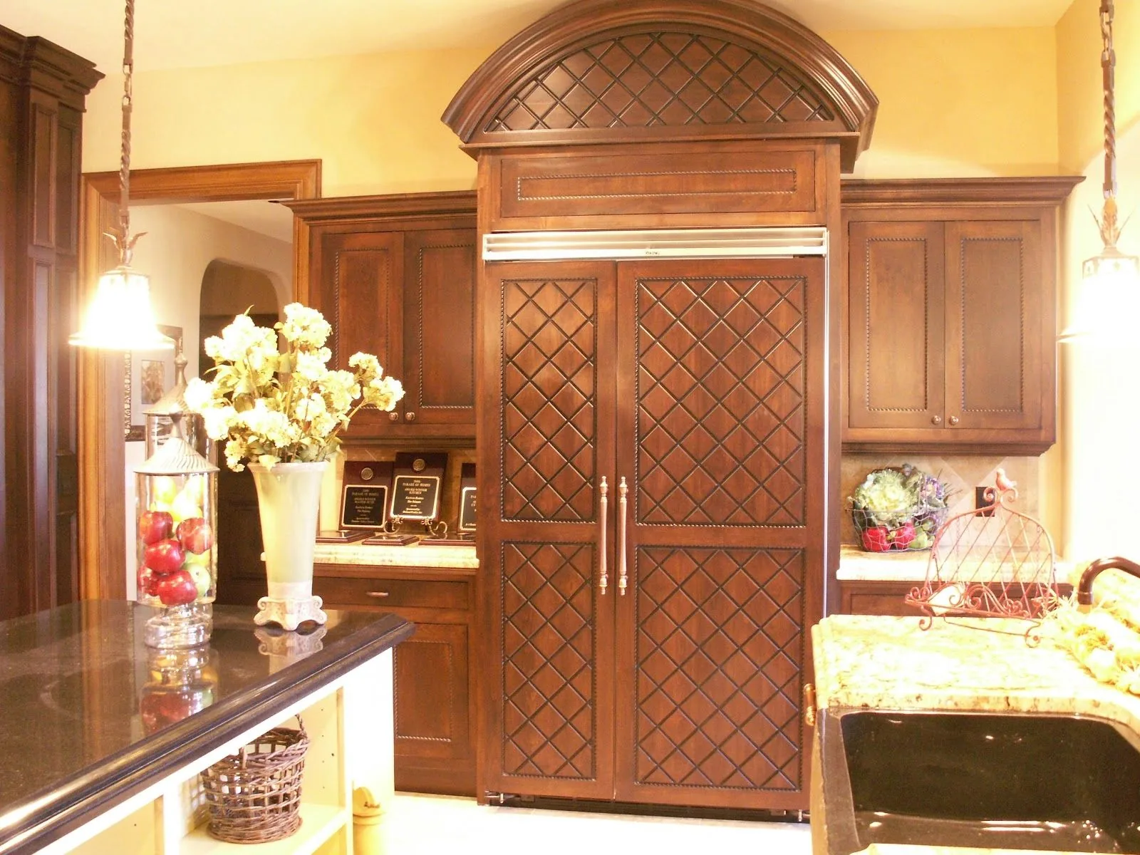 Stained refrigerator surround with lattice panel doors and arched top